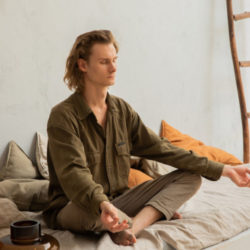 A man meditating on bed